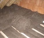 Sheep Wool Insulation Comfort Roll being installed at ceiling level between and over floor joists.